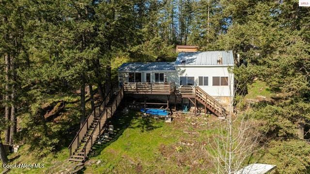 24010 N Bridge Lake Rd, Rathdrum, ID 83858 - back of house with stairs, a wooden deck, metal roof, and a view of trees