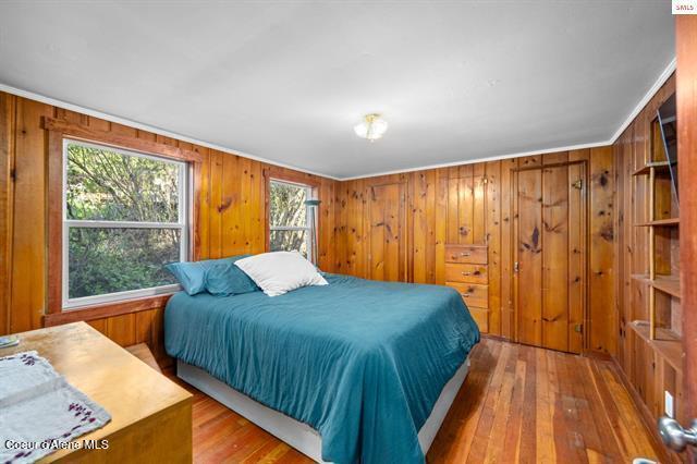 24010 N Bridge Lake Rd, Rathdrum, ID 83858 - bedroom with hardwood / wood-style floors and wood walls