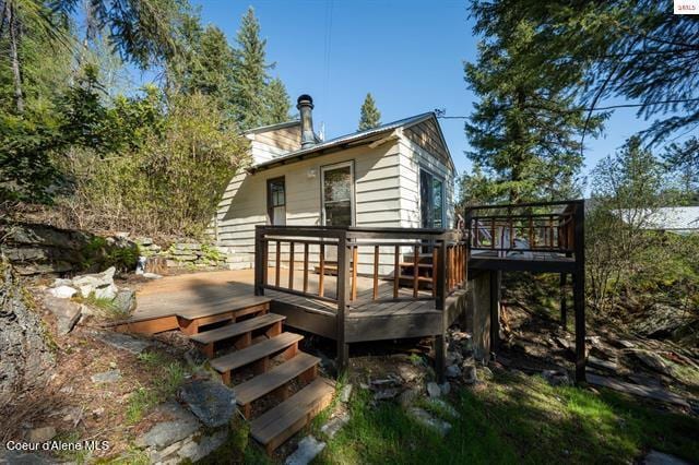 24010 N Bridge Lake Rd, Rathdrum, ID 83858 - back of property featuring a deck and a chimney