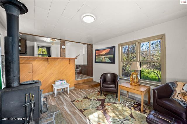 24010 N Bridge Lake Rd, Rathdrum, ID 83858 - living area featuring a wood stove and wood finished floors