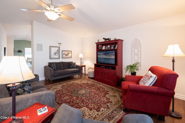 living room with wood finished floors, vaulted ceiling, ceiling fan, and baseboards