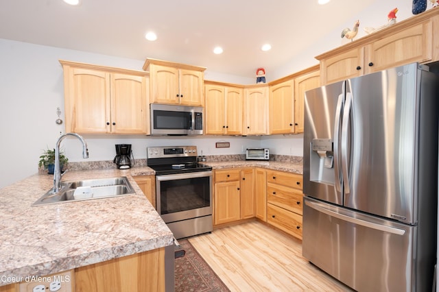 kitchen with appliances with stainless steel finishes, light brown cabinetry, a sink, light wood-style floors, and recessed lighting