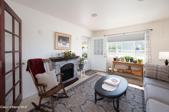 living room with a stone fireplace and french doors