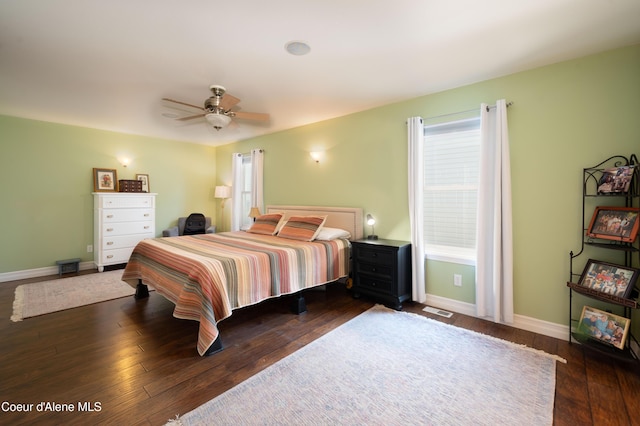 bedroom with multiple windows, baseboards, dark wood-style flooring, and ceiling fan