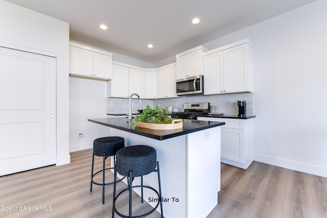 717 N Creative Way, Post Falls, ID 83854 - kitchen featuring stainless steel appliances, dark countertops, baseboards, decorative backsplash, and recessed lighting