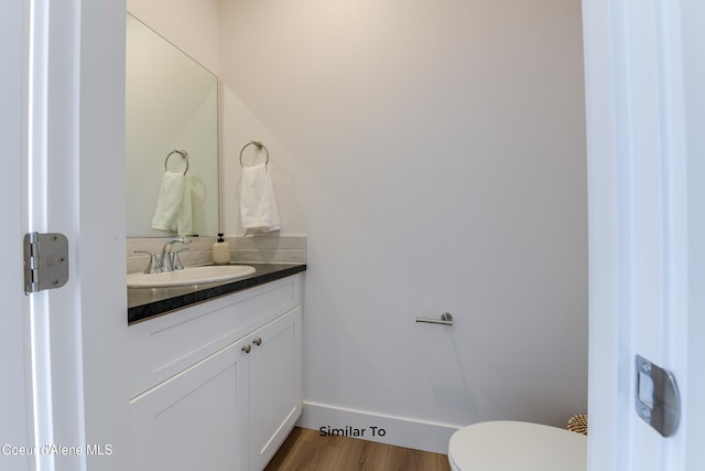 717 N Creative Way, Post Falls, ID 83854 - half bathroom featuring vanity, wood finished floors, toilet, and baseboards