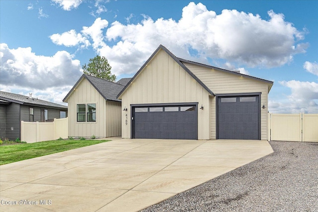view of front of property with fence, board and batten siding, driveway, and a garage