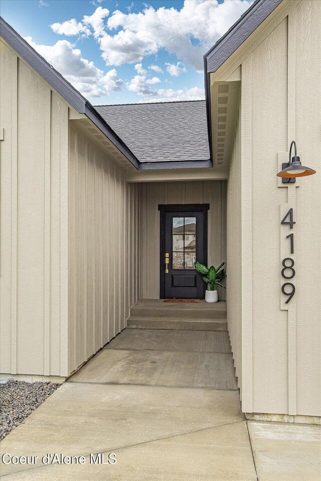 doorway to property featuring a shingled roof