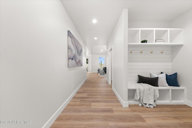 hall featuring light wood-style floors, baseboards, and recessed lighting