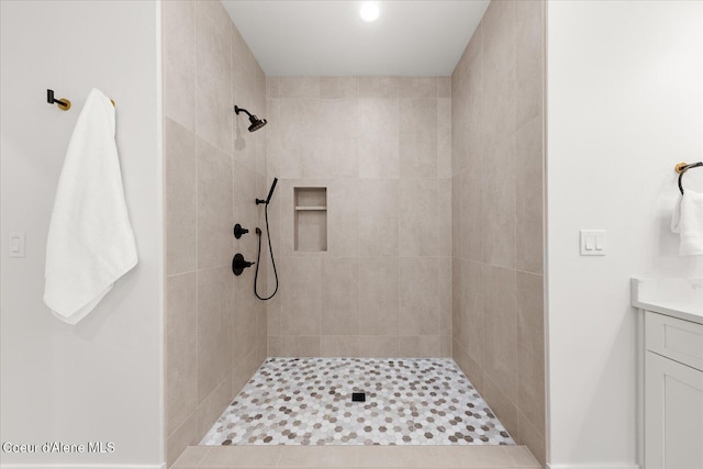 bathroom featuring a tile shower and vanity