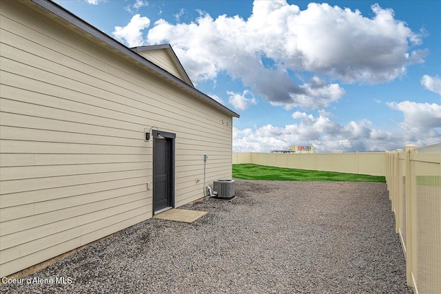 view of yard with fence and central AC
