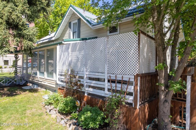 610 W Emma Ave, Coeur Dalene, ID 83814 - view of property exterior with a lawn, a sunroom, and metal roof