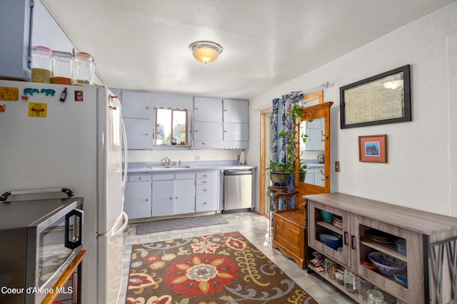 610 W Emma Ave, Coeur Dalene, ID 83814 - kitchen featuring stainless steel appliances, a sink, light countertops, and a textured wall