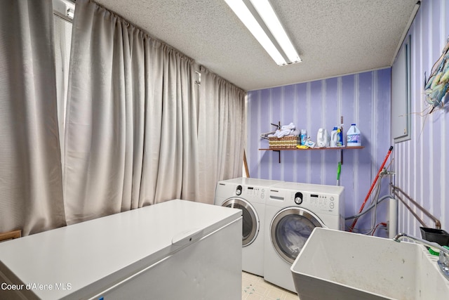 610 W Emma Ave, Coeur Dalene, ID 83814 - laundry room featuring washing machine and dryer, wallpapered walls, a textured ceiling, and light floors
