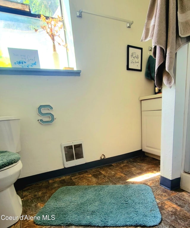 610 W Emma Ave, Coeur Dalene, ID 83814 - bathroom with baseboards, stone finish floors, and toilet