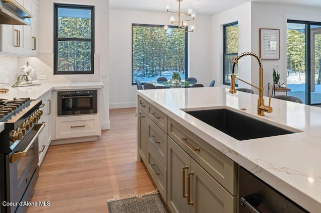 624 Satchel Dr, Spirit Lake, ID 83869 - kitchen with a sink, stainless steel appliances, under cabinet range hood, light wood-type flooring, and light stone countertops