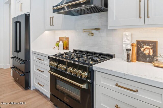 624 Satchel Dr, Spirit Lake, ID 83869 - kitchen with black appliances, exhaust hood, light stone countertops, tasteful backsplash, and white cabinets