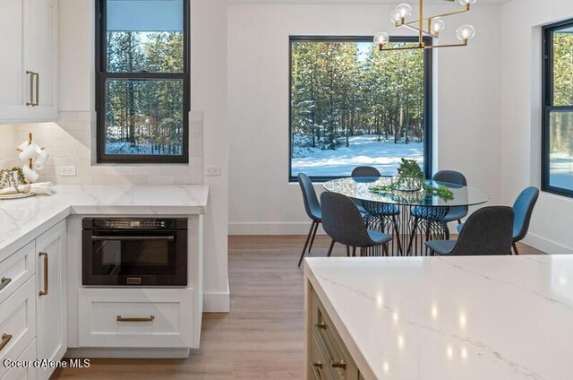 624 Satchel Dr, Spirit Lake, ID 83869 - dining space featuring a chandelier, light wood-type flooring, and baseboards