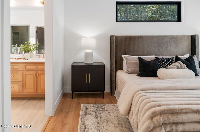 624 Satchel Dr, Spirit Lake, ID 83869 - bedroom featuring light wood-style flooring, ensuite bathroom, and a sink