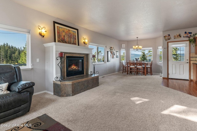 9798 N Willowherb Ct, Hauser, ID 83854 - carpeted living room with a chandelier, a fireplace, and healthy amount of natural light