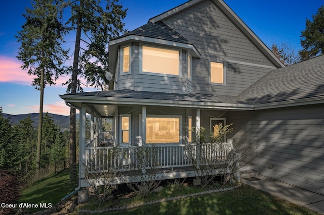 9798 N Willowherb Ct, Hauser, ID 83854 - view of front of property with a porch, roof with shingles, and a mountain view