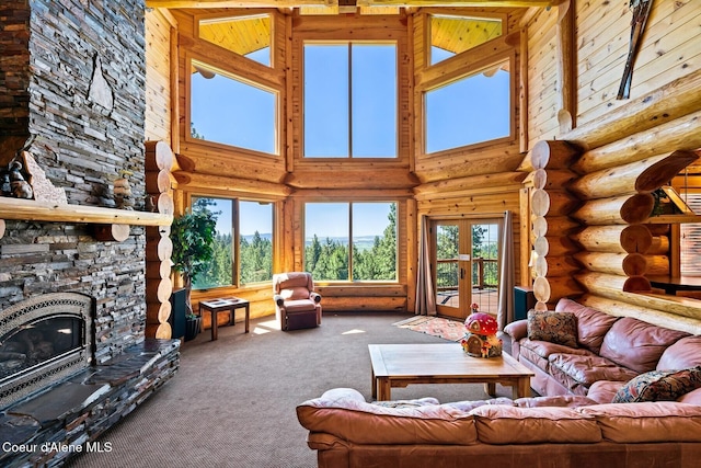 1050 Greenview Ln, Moscow, ID 83843 - carpeted living room with log walls, a fireplace, and a towering ceiling