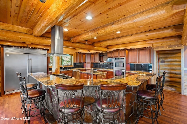 1050 Greenview Ln, Moscow, ID 83843 - kitchen featuring appliances with stainless steel finishes, a large island with sink, dark wood finished floors, recessed lighting, and island range hood