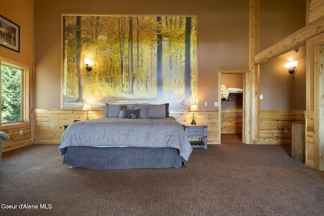 1050 Greenview Ln, Moscow, ID 83843 - bedroom featuring carpet floors, wood walls, a wainscoted wall, and a towering ceiling