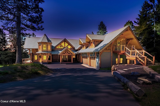 1050 Greenview Ln, Moscow, ID 83843 - view of front of house featuring stairs, asphalt driveway, a garage, and covered porch