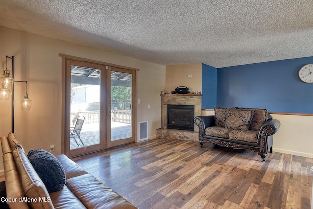 4413 W Pleasant Ln, Post Falls, ID 83854 - living area featuring a textured ceiling, wood finished floors, a fireplace, baseboards, and french doors