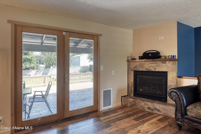 4413 W Pleasant Ln, Post Falls, ID 83854 - entryway with wood-type flooring, healthy amount of natural light, a textured ceiling, and a tile fireplace