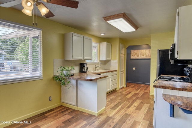 4413 W Pleasant Ln, Post Falls, ID 83854 - kitchen with a ceiling fan, light wood-type flooring, white cabinets, and tasteful backsplash