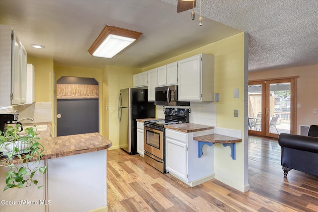 4413 W Pleasant Ln, Post Falls, ID 83854 - kitchen with appliances with stainless steel finishes, backsplash, and white cabinets
