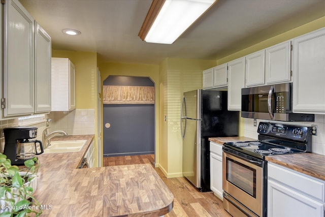 4413 W Pleasant Ln, Post Falls, ID 83854 - kitchen featuring stainless steel appliances, a sink, backsplash, white cabinets, and recessed lighting