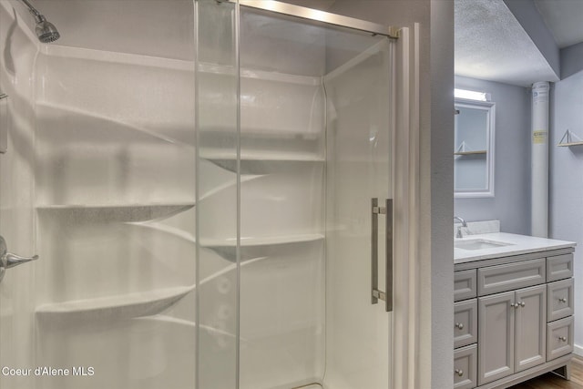 4413 W Pleasant Ln, Post Falls, ID 83854 - full bathroom featuring a stall shower, vanity, and a textured ceiling