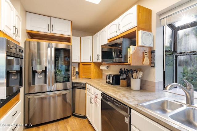 11624 N W Newman Lake Dr, Newman Lake, WA 99025 - kitchen featuring stainless steel appliances, a sink, white cabinets, light wood-style floors, and light countertops