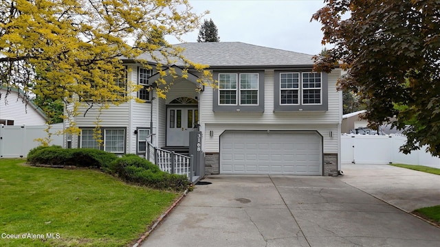 3168 N 9th St, Coeur Dalene, ID 83815 - bi-level home with an attached garage, driveway, stone siding, and a gate