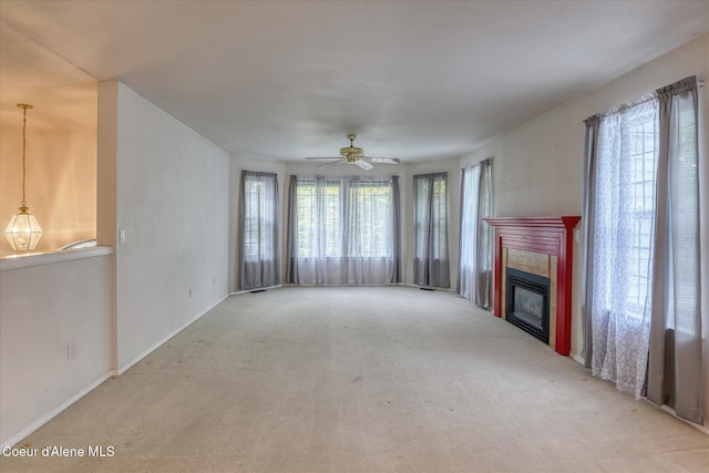 3168 N 9th St, Coeur Dalene, ID 83815 - unfurnished living room featuring carpet flooring, a ceiling fan, a glass covered fireplace, and baseboards