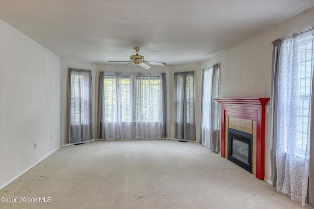 3168 N 9th St, Coeur Dalene, ID 83815 - unfurnished living room featuring a tiled fireplace, plenty of natural light, carpet floors, and ceiling fan
