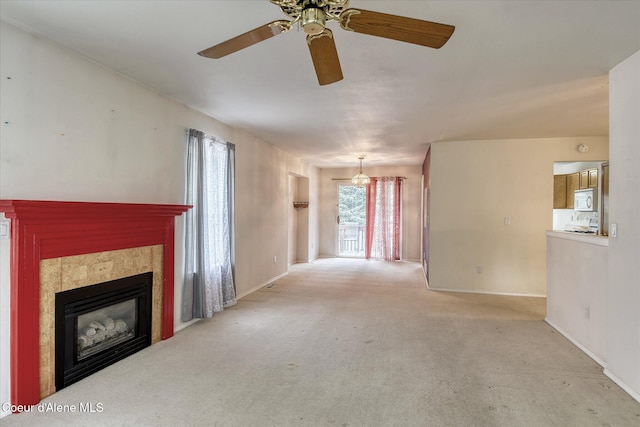 3168 N 9th St, Coeur Dalene, ID 83815 - unfurnished living room featuring a ceiling fan, a tiled fireplace, baseboards, and carpet