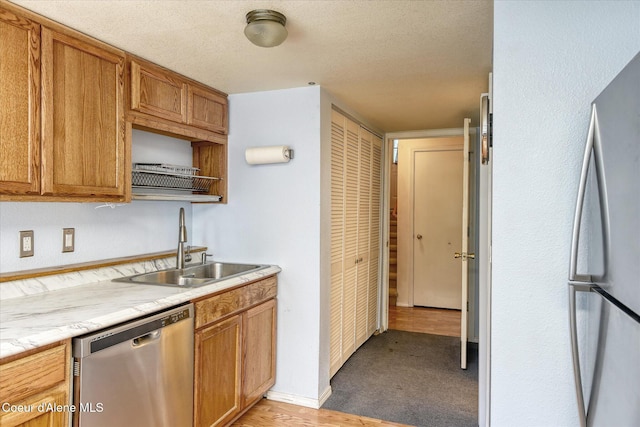 3168 N 9th St, Coeur Dalene, ID 83815 - kitchen featuring stainless steel appliances, a sink, light countertops, brown cabinetry, and a textured ceiling