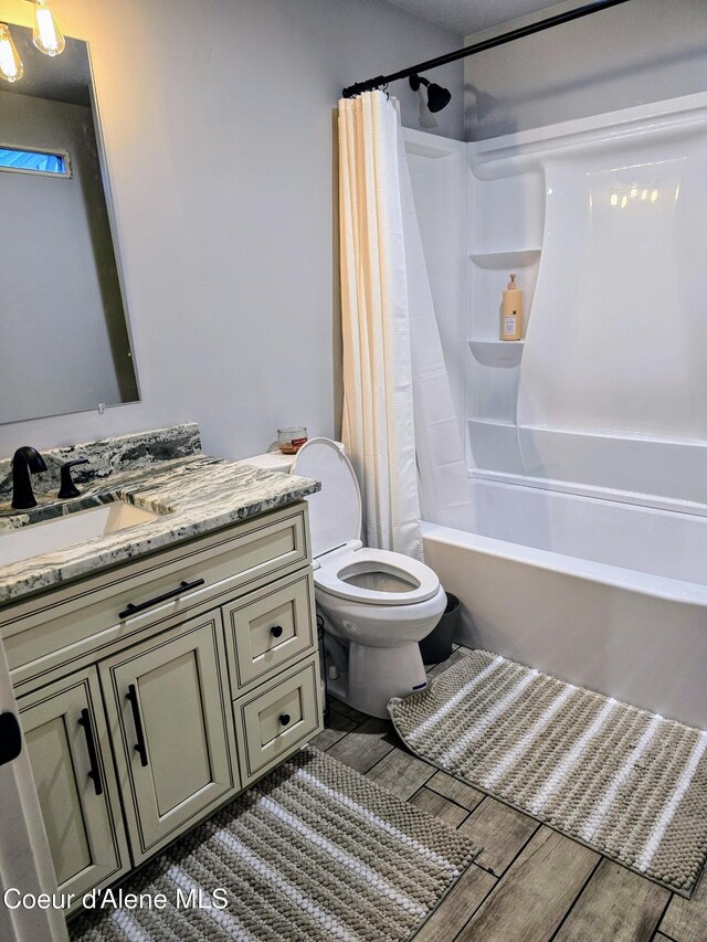 117 River St, Wallace, ID 83873 - full bathroom with wood finished floors, vanity, shower / bath combo with shower curtain, and toilet