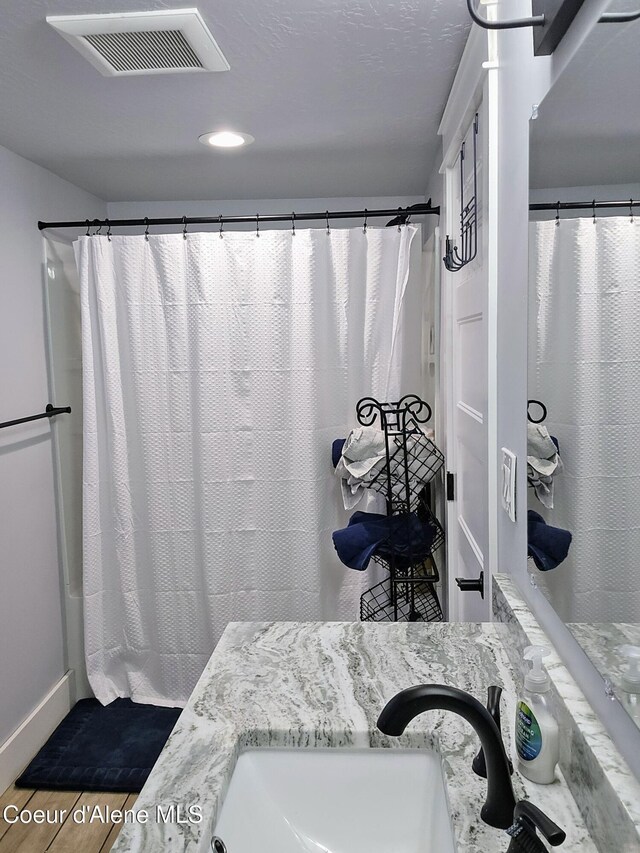 117 River St, Wallace, ID 83873 - full bathroom with wood finished floors, a shower with curtain, recessed lighting, and vanity