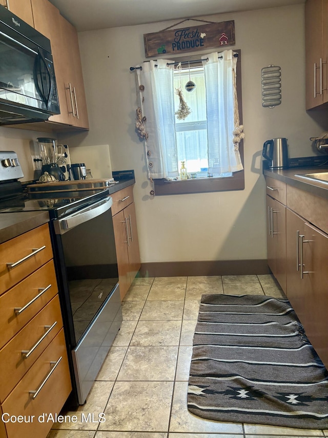 235 S 5th St, Saint Maries, ID 83861 - kitchen featuring black microwave, electric stove, dark countertops, light tile patterned floors, and brown cabinets
