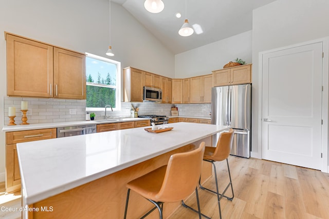204 Silver Saddle Ct, Pinehurst, ID 83850 - kitchen featuring stainless steel appliances, a sink, high vaulted ceiling, decorative backsplash, and a kitchen breakfast bar