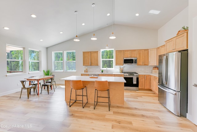 204 Silver Saddle Ct, Pinehurst, ID 83850 - kitchen featuring stainless steel appliances, light countertops, a center island, light wood finished floors, and light brown cabinetry