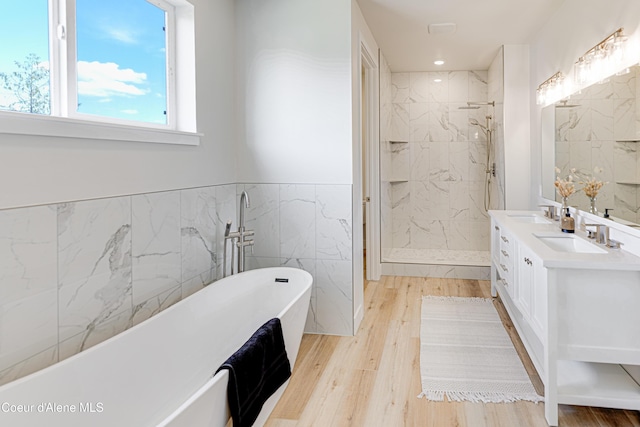 204 Silver Saddle Ct, Pinehurst, ID 83850 - full bath with tile walls, a shower stall, a freestanding bath, wood finished floors, and a wainscoted wall