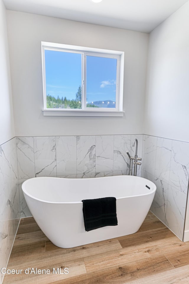 204 Silver Saddle Ct, Pinehurst, ID 83850 - full bath featuring tile walls, a freestanding bath, wainscoting, and wood finished floors