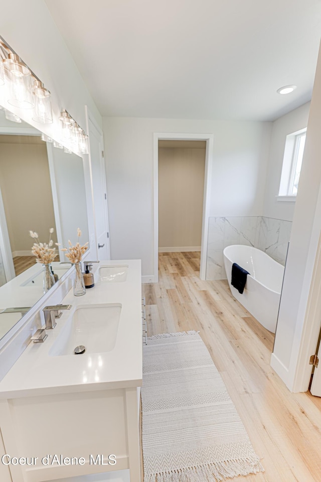 204 Silver Saddle Ct, Pinehurst, ID 83850 - full bathroom featuring wood finished floors, a freestanding tub, and double vanity