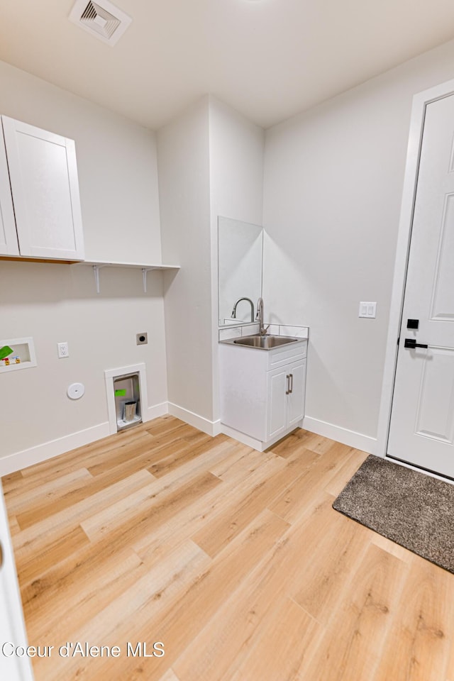 204 Silver Saddle Ct, Pinehurst, ID 83850 - laundry room with hookup for an electric dryer, light wood finished floors, washer hookup, hookup for a gas dryer, and cabinet space